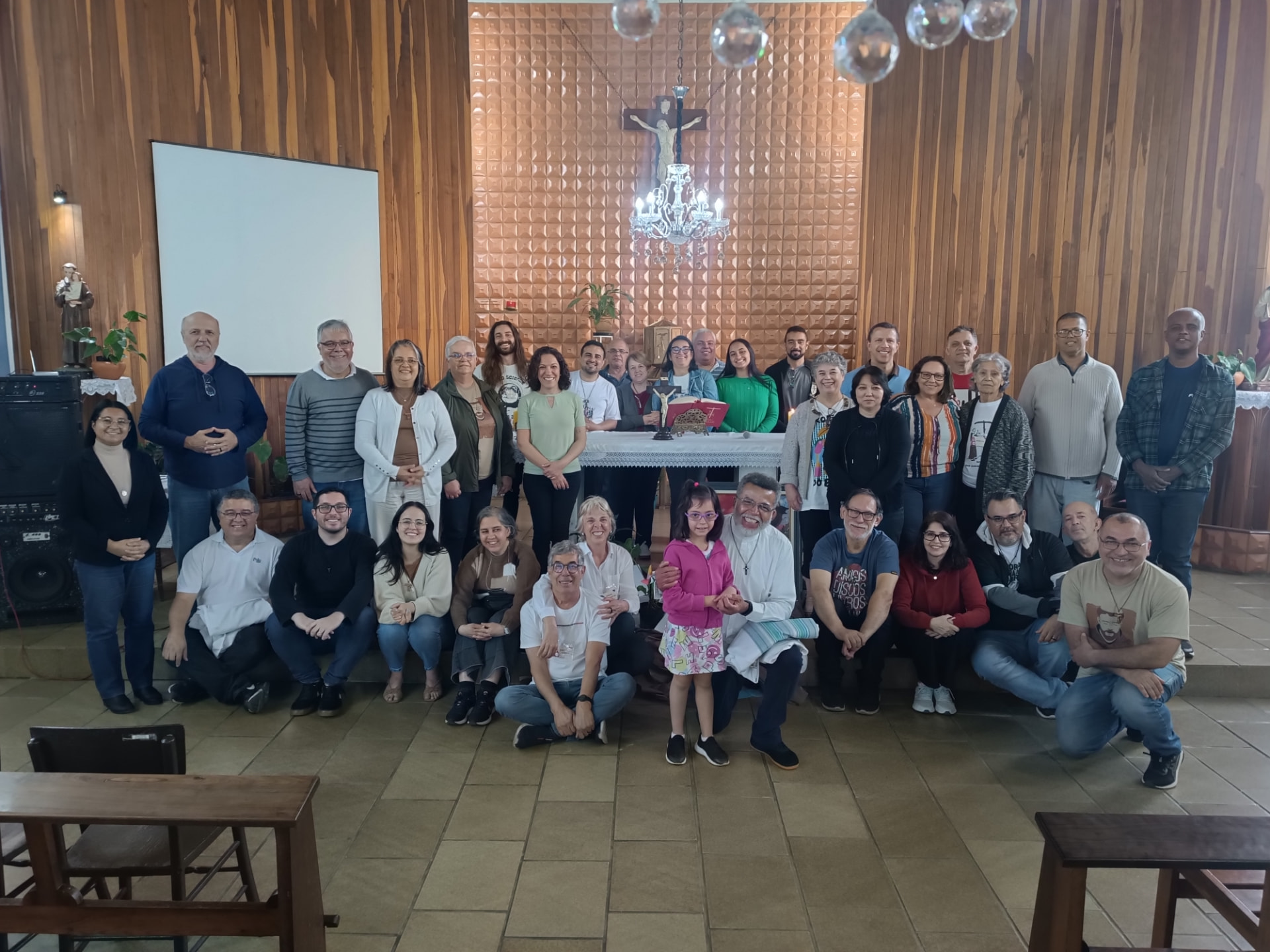 Irmãos e irmãs da Fraternidade São Francisco de Assis reunidos diante do altar