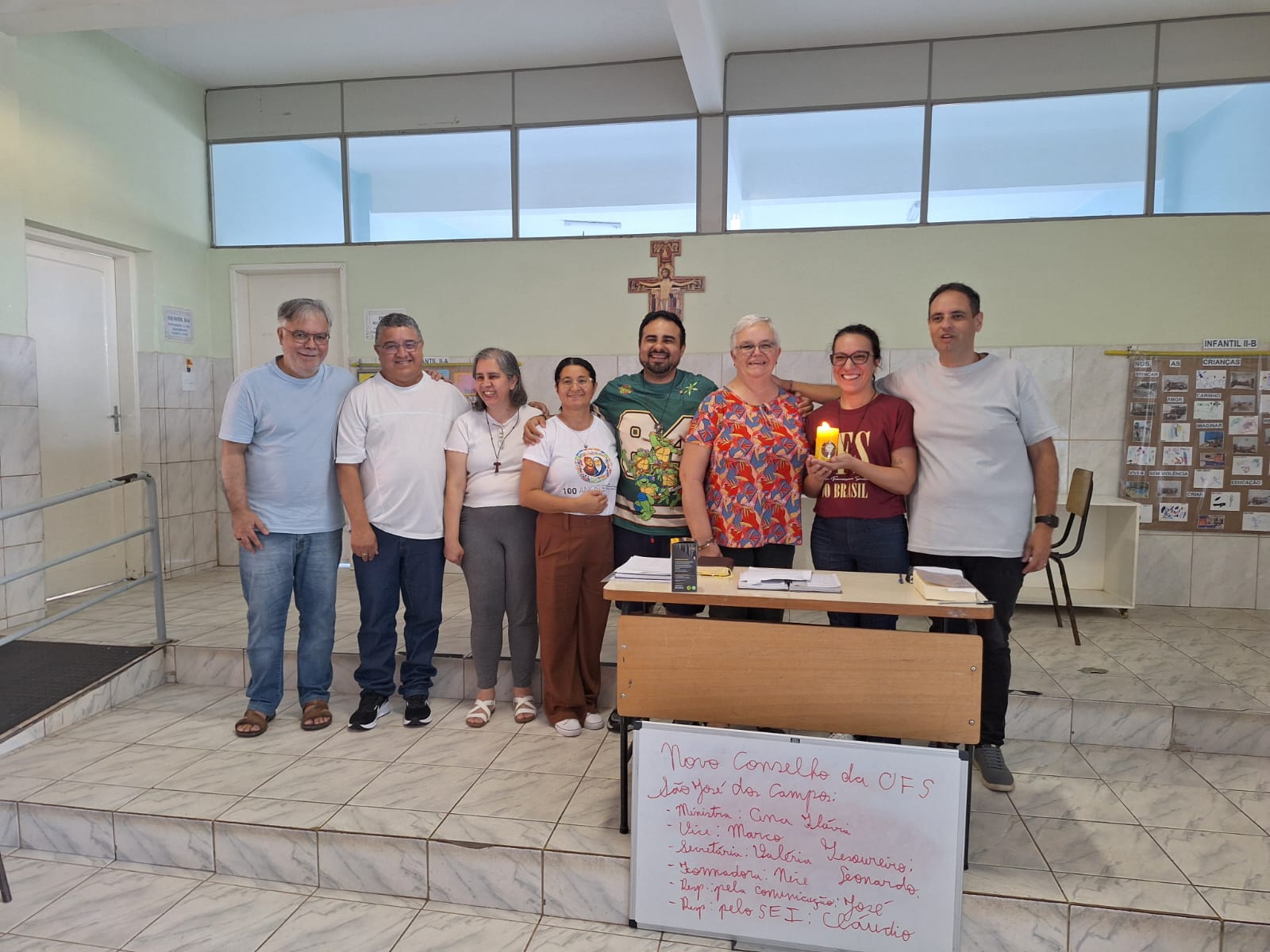 O novo Conselho da OFS São José dos Campos reunido após o Capítulo Eletivo, diante do quadro com os nomes eleitos