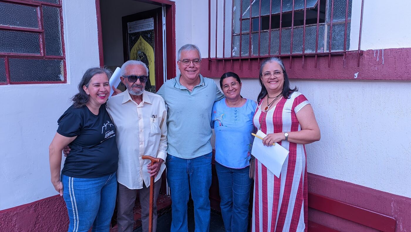 Grupo de irmãos e irmãs da fraternidade posando juntos na entrada da capela