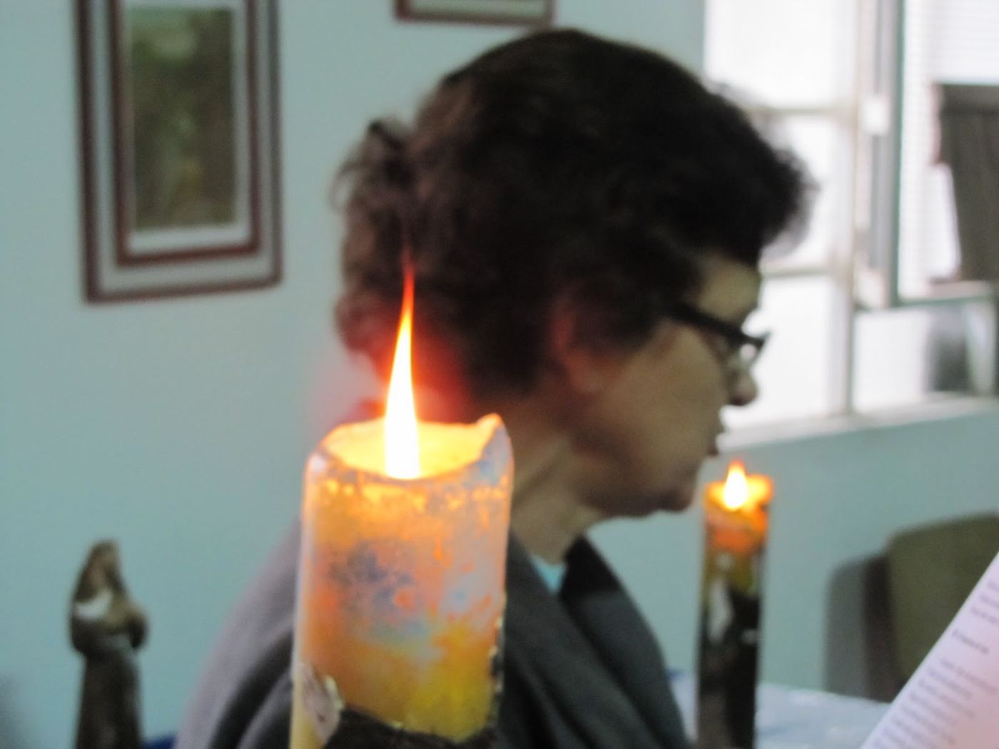 Vela acesa diante de uma imagem durante a oração da fraternidade
