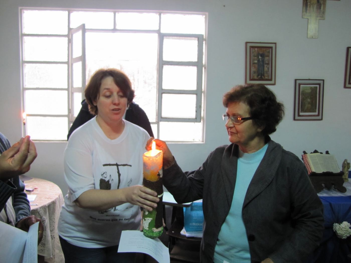 Irmãs segurando velas acesas durante a celebração de iniciação