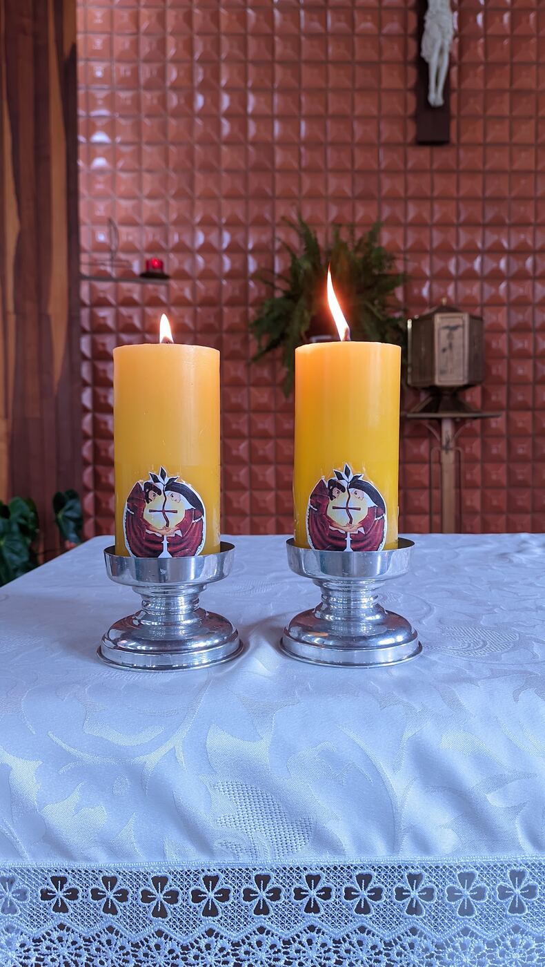 Velas franciscanas acesas sobre o altar na profissão de Cláudio Oliveira